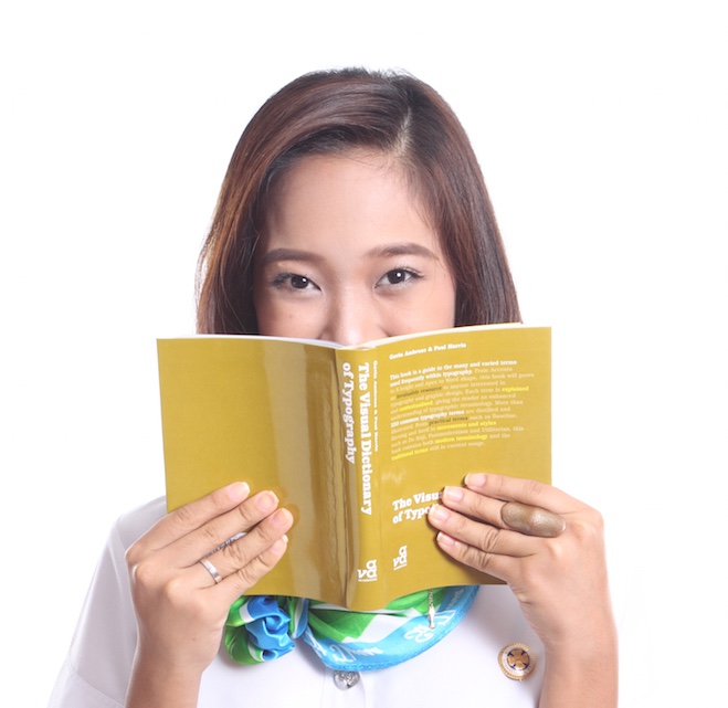 Student hiding her face with a book